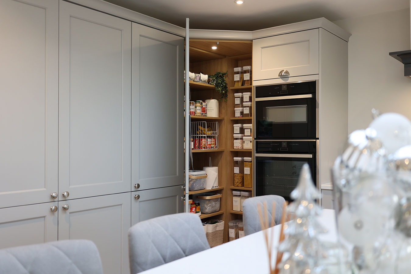 Traditional kitchen with white cabinets, black oven, and dining area.